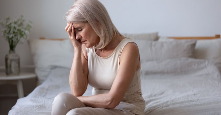 femme avec des déséquilibres hormonaux se tient la tête et cherche des remèdes naturels pour les contrer